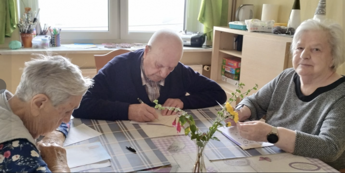 Starsze osoby wypisują listy